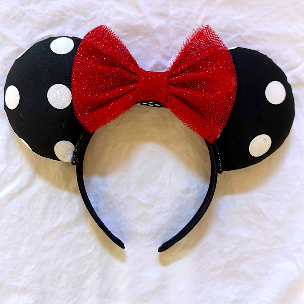 Black and white polka dot Minnie Mouse ears with red sparkly bow